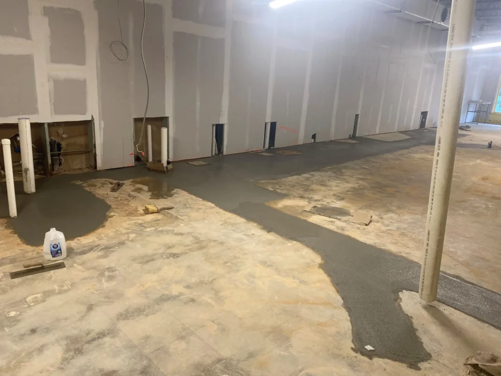 A room featuring bare concrete flooring