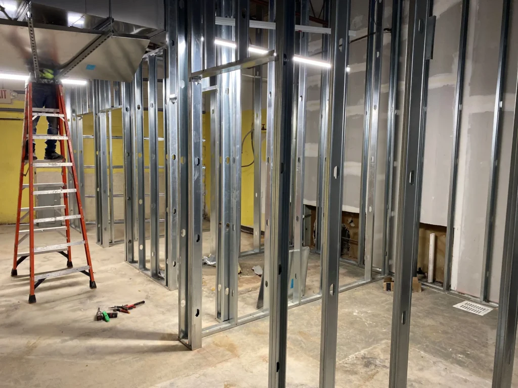 A room featuring metal framing and a ladder leaning against the wall