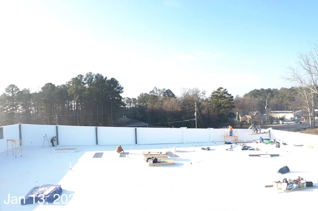 A large white roof featuring construction equipment