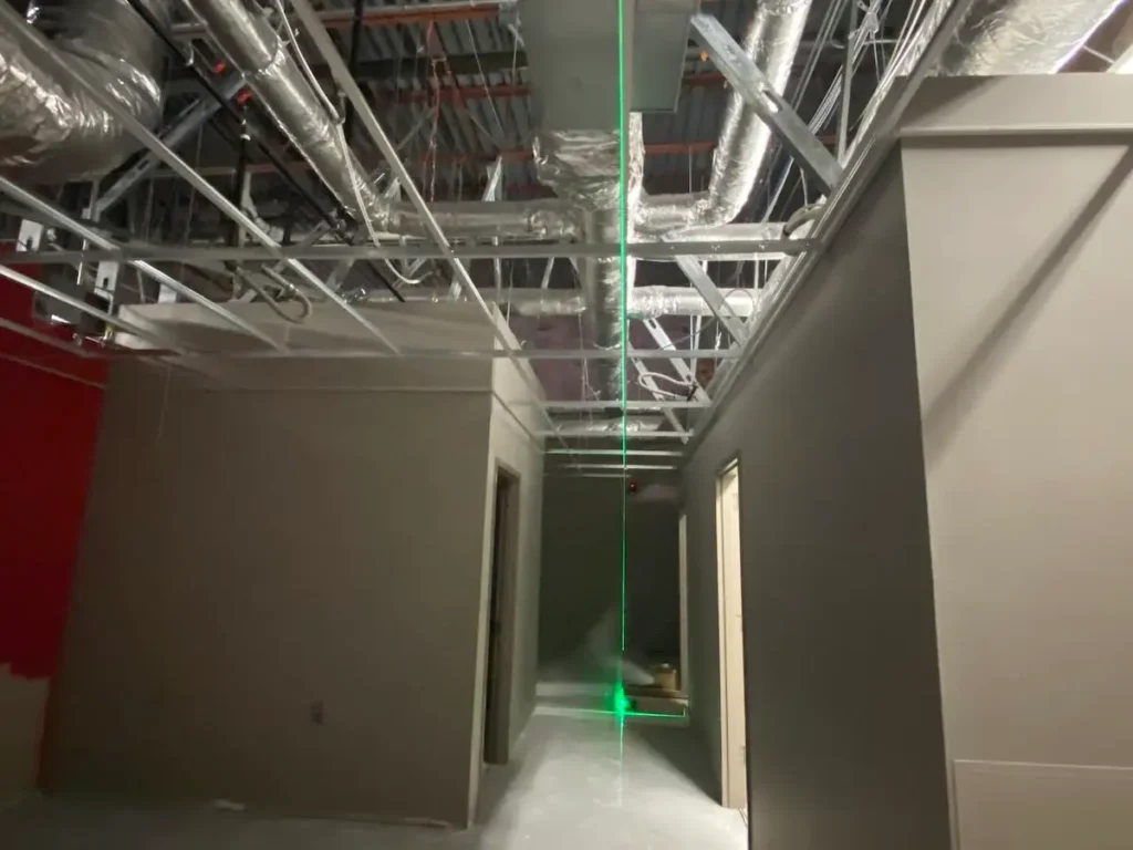 A corridor with a green light filtering through the ceiling