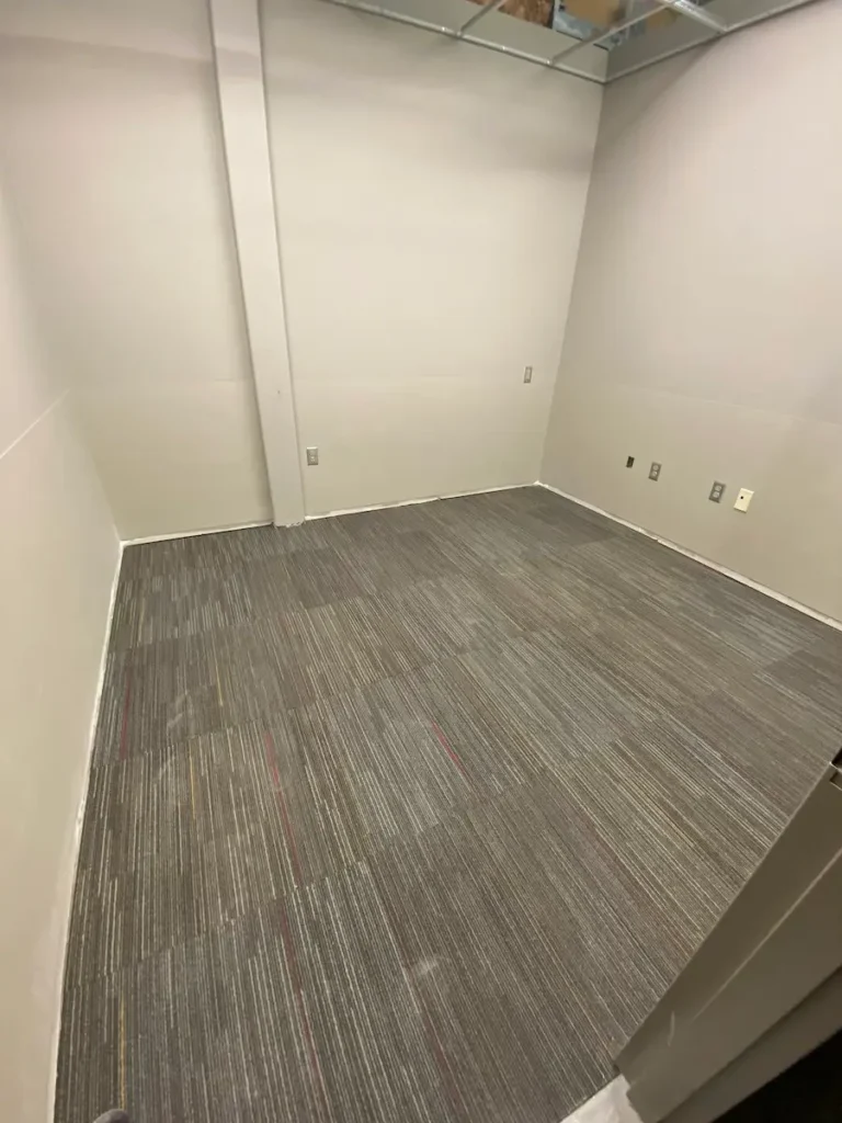 Empty office space featuring gray walls and carpeting