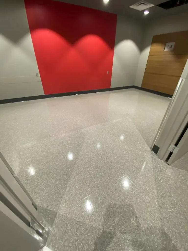 A spacious room featuring a vibrant red wall and a clean white floor