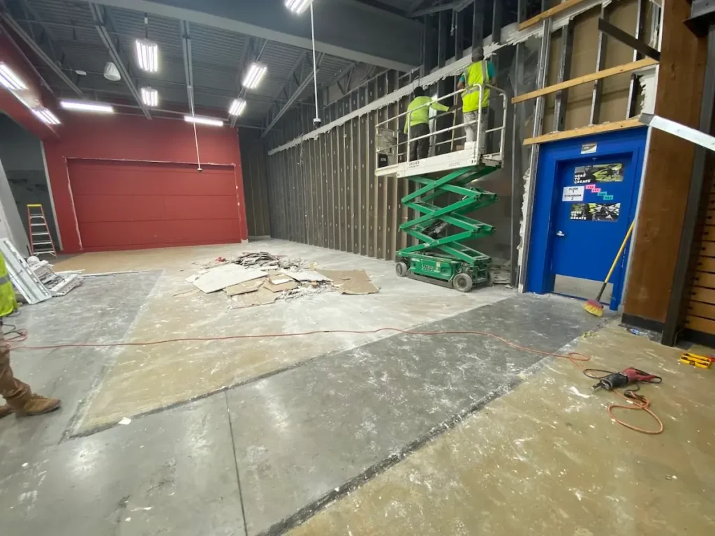 A group of construction workers is actively working on the interior of a building