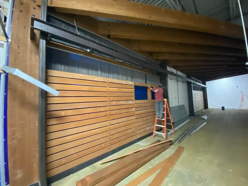 A man is repairing a wooden door inside a building