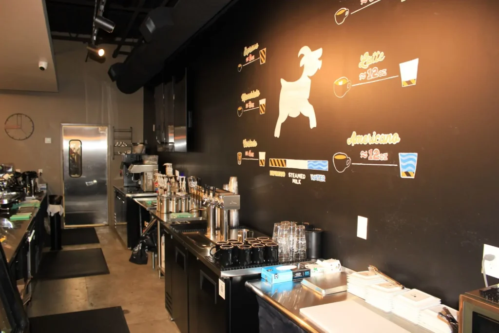 A cozy coffee shop featuring a mural of a dog on the wall