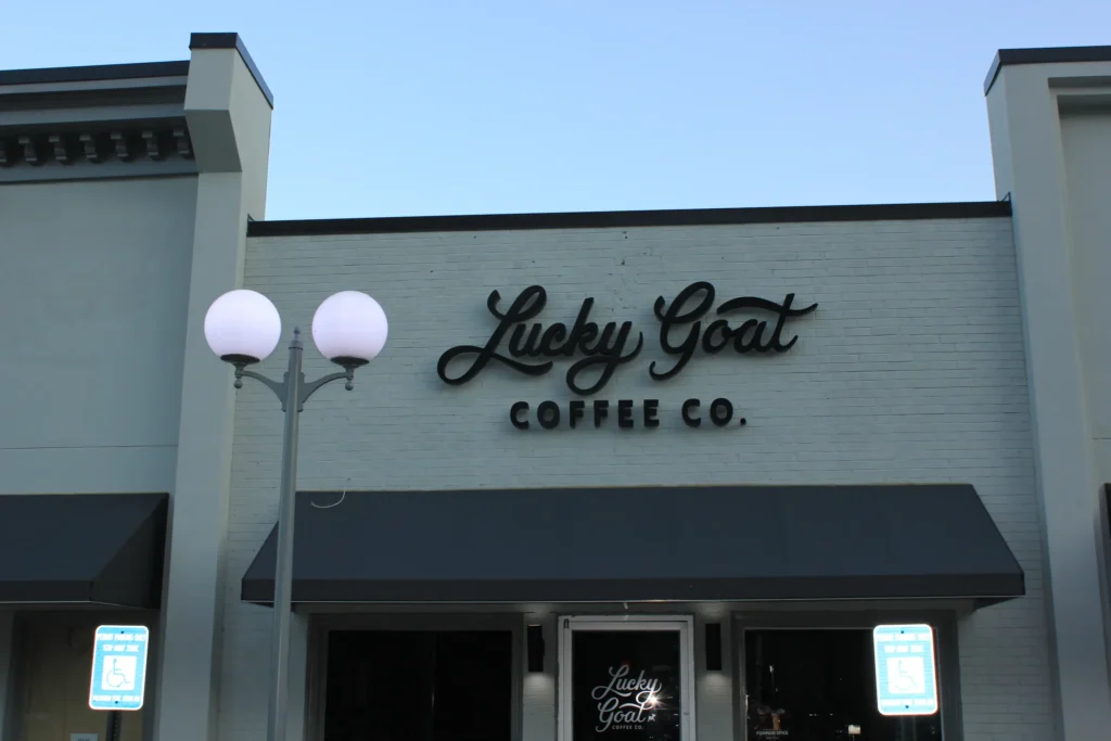 A coffee shop building showcasing a sign that says "Lucky Goat Coffee Co." at the entrance.