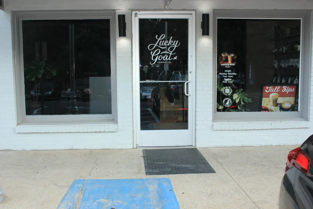 A black car parked in front of a retail store