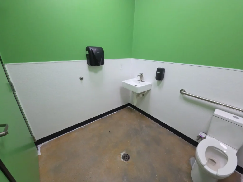 A bathroom featuring green walls and a white toilet