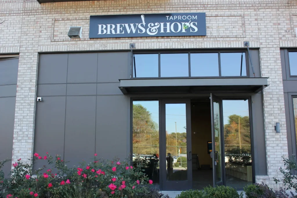 The corner of a brick building with shops and brews