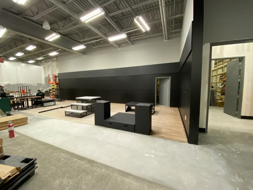 A spacious room featuring black walls and polished wooden floors