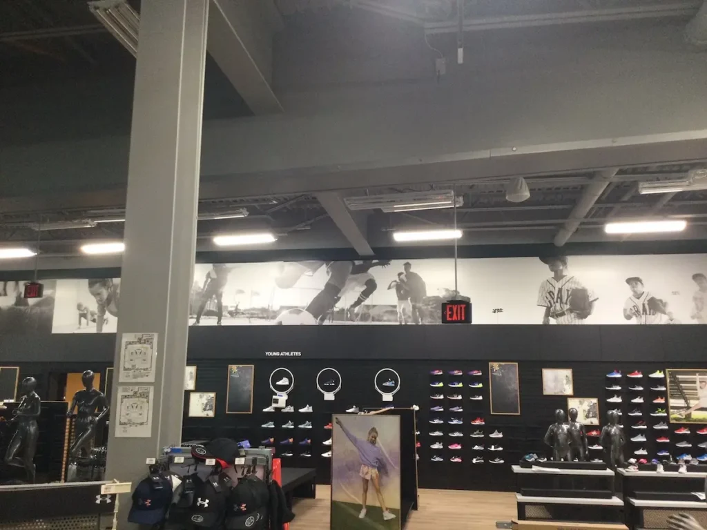 A store showcases a large picture wall complemented by a clock