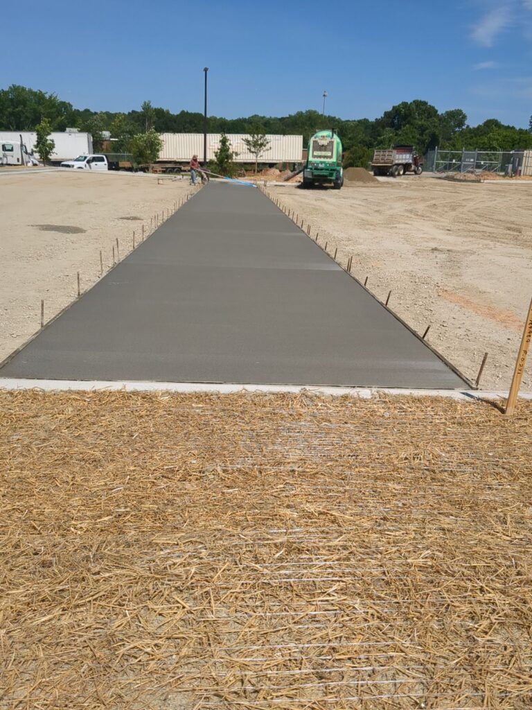 Reinforced concrete loading apron installation for commercial parking lot and truck delivery