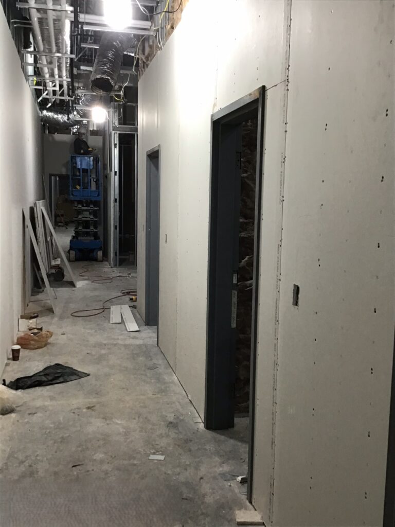 Lidl supermarket hallway drywall installation and overhead HVAC rough-in during interior commercial construction in Decatur GA