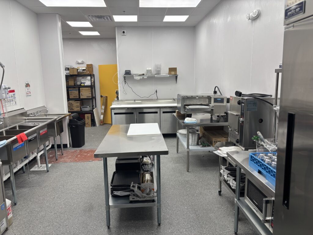 Commercial kitchen preparation area with stainless steel equipment and food service workstations