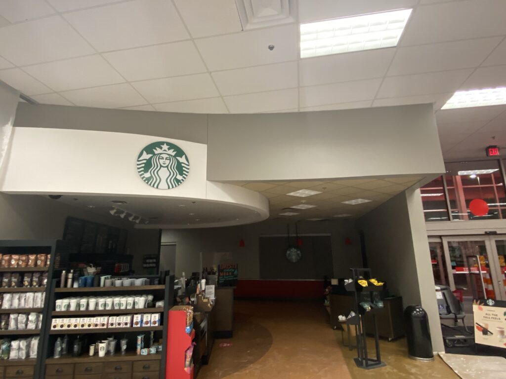 Target Starbucks remodel with completed soffit construction, ACT ceiling, and finished retail interior build-out