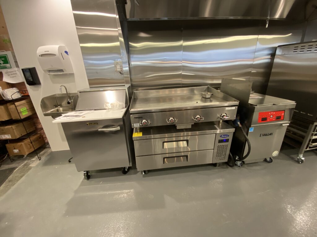Convenience store remodel back of house grill or cook line with stainless equipment and vent hood