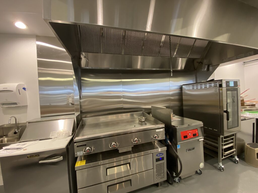 Convenience store back of house stainless cook line with fryers grill and large exhaust hood