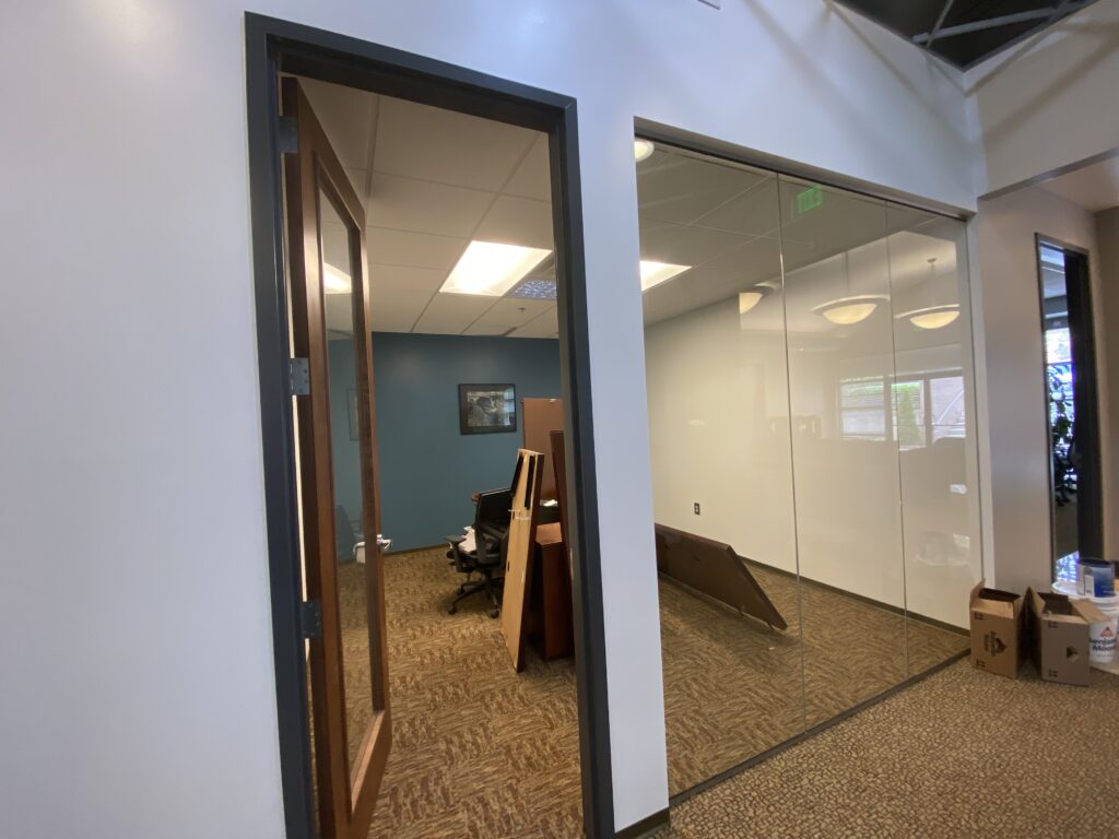 Glass office partition system and private office entrance in commercial workspace