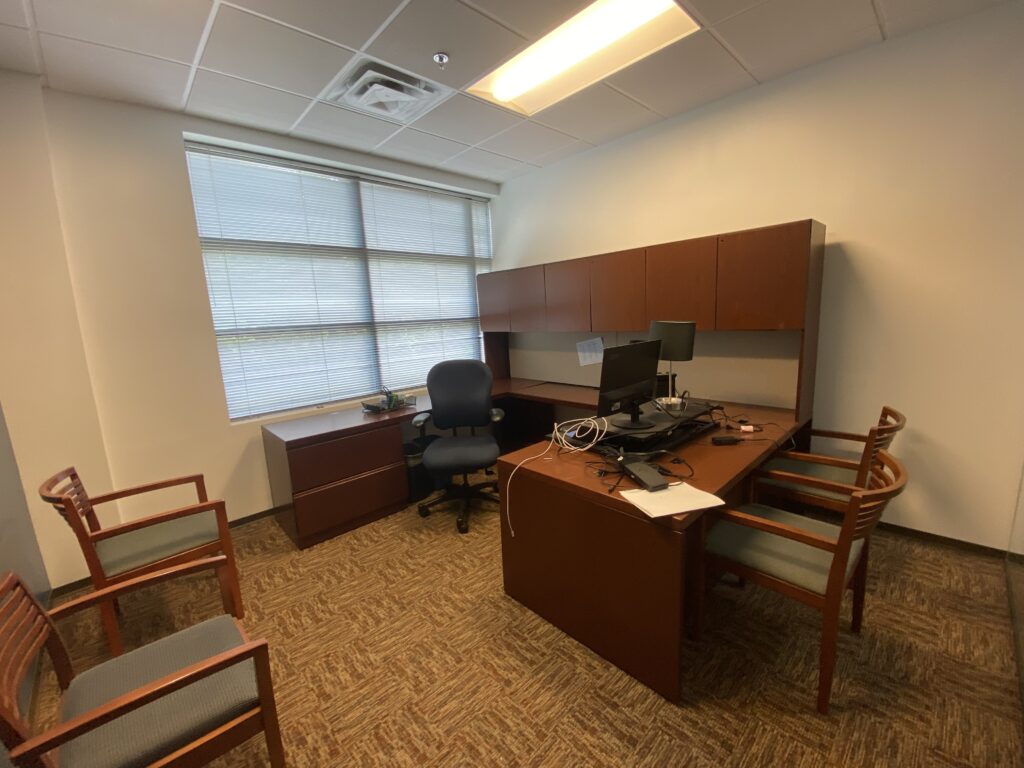 Finished private office in Decatur GA with large window, desk, and carpet flooring