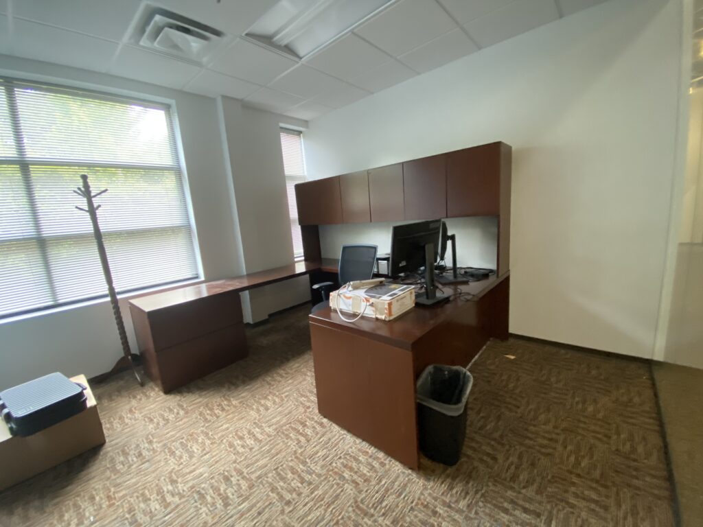 private office in Decatur GA with large windows, L-shaped desk, and carpet flooring