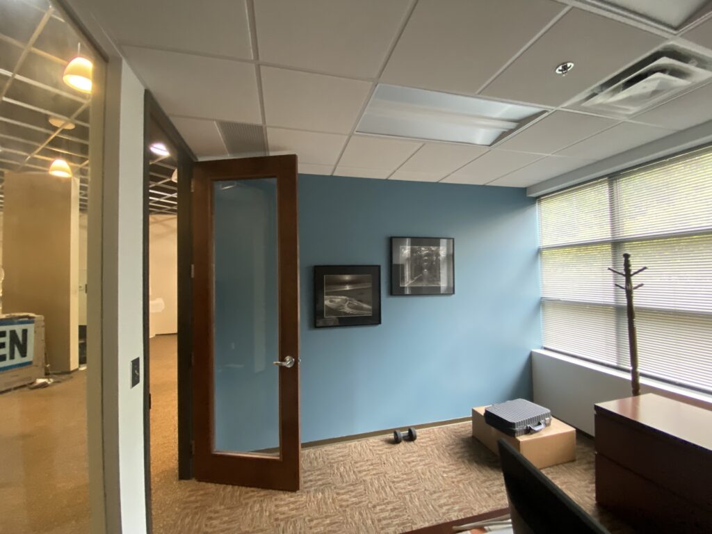 Office build out in Decatur GA with wood door, glass lite, and blue feature wall inside private office