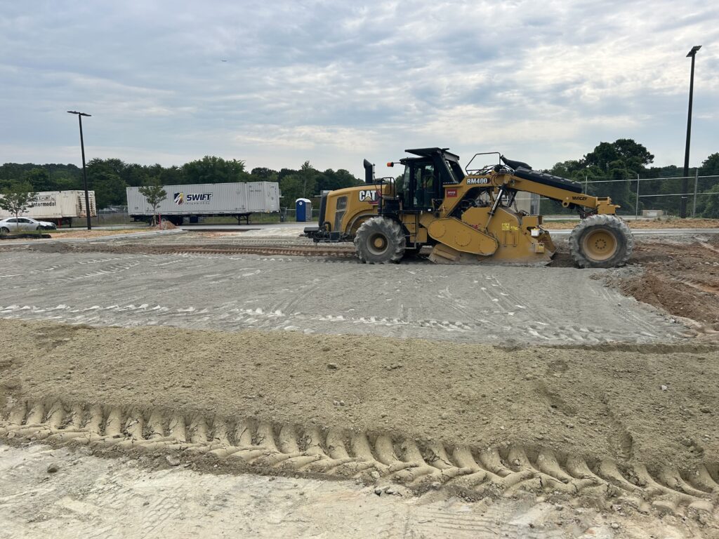 Front end loader spreading and grading stone base for warehouse truck parking lot in Decatur GA