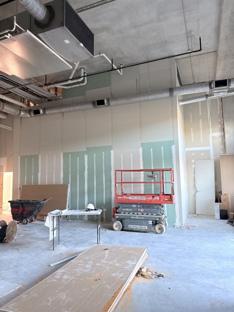 Drywall finishing and interior construction progress in commercial taproom project