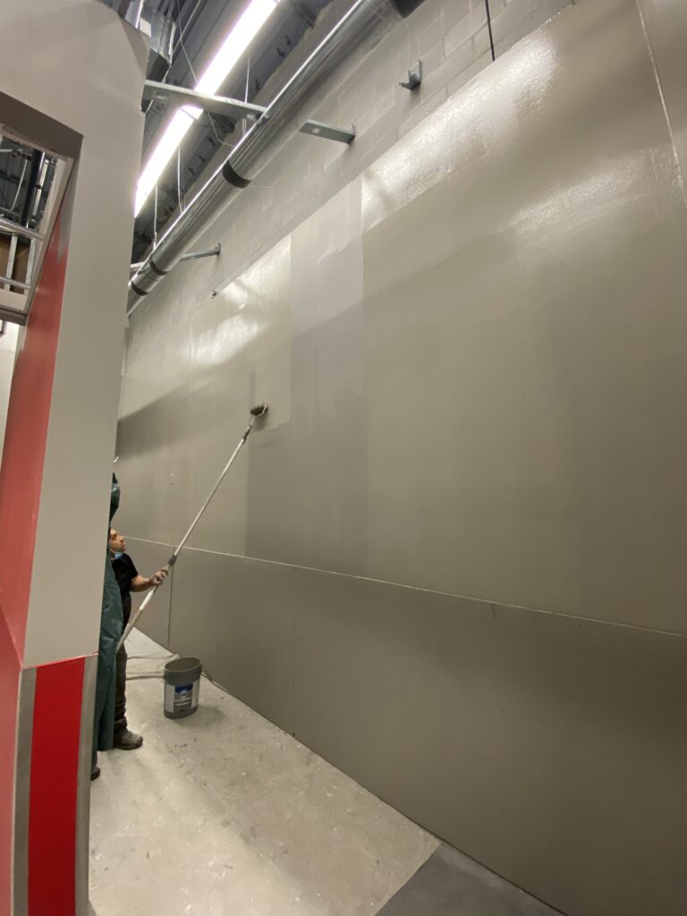 Commercial painting work during Target remodel with finished drywall and exposed industrial ceiling systems