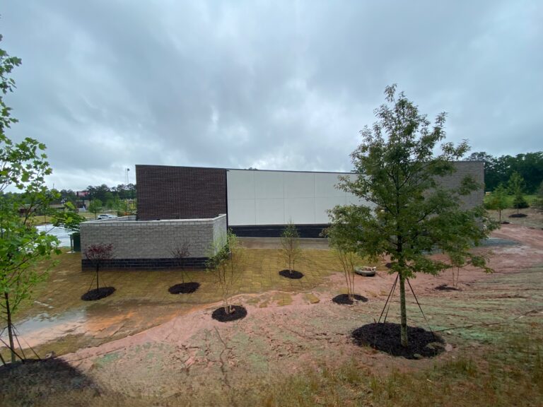 Completed rear exterior landscaping and final site stabilization at Lidl grocery store construction project in Decatur GA during rainy weather
